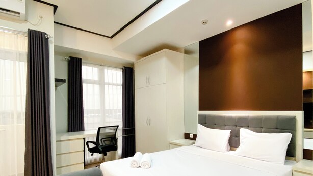 Une chambre d’hôtel moderne avec un grand lit, un bureau et une chaise.