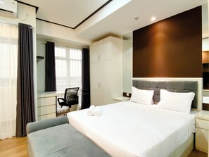 Une chambre d’hôtel moderne avec un grand lit, un bureau et une chaise.