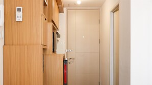 Une armoire en bois dotée d’un panneau de commande, d’une porte avec une poignée et d’un objet rouge suspendu à la porte.