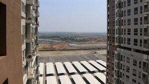 A high-rise building with multiple balconies and a view of a construction site below. - Modern And New Studio At Tokyo Riverside Pik 2 Apartment (Teluknaga)