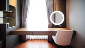Quarto moderno com escrivaninha de madeira, espelho redondo e uma cadeira.