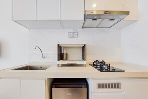 Una cocina moderna con un lavamanos de acero inoxidable, un horno empotrado y un refrigerador GEA.