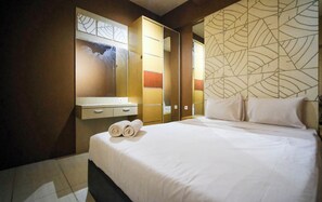Une chambre d’hôtel avec un grand lit, une armoire, un miroir et un panneau décoratif au mur.
