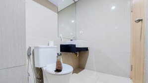A modern bathroom with a toilet, a sink, and a mirror. - Comfort 1Br Without Living Room Bintaro Embarcadero Apartment (South Tangerang)