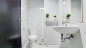 Een moderne badkamer met toilet, wastafel en potplanten.