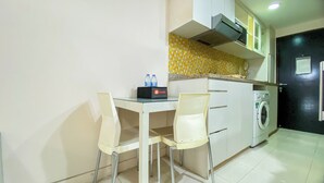 A small kitchenette with a table and chairs, a washing machine, and a microwave.