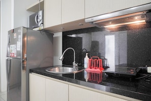 Een koelkast met diepvriezer, een kookplaat