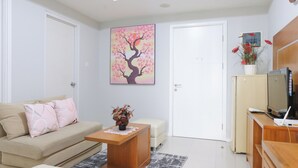 Una sala de estar moderna con un sofá, una mesa de centro y un cuadro de un árbol.