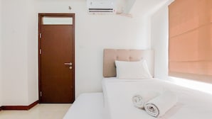 Una habitación de hotel con cama, puerta y aire acondicionado.