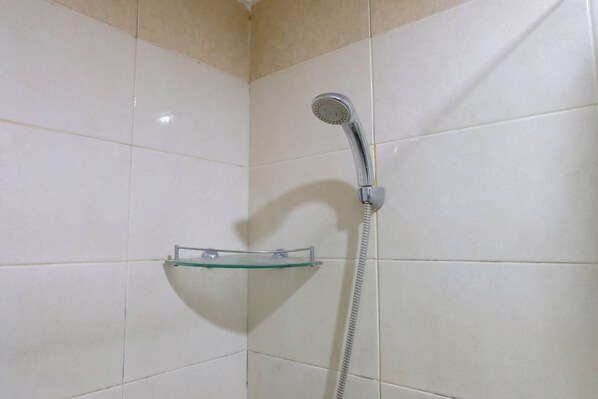 A shower with a glass shelf and a handheld showerhead.