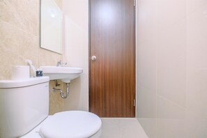 Une salle de bain avec des toilettes, un lavabo et un miroir.