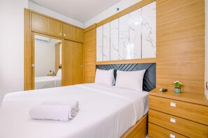 Une chambre à coucher moderne avec une armoire en bois, une tête de lit en marbre, un lit bien fait avec du linge de lit blanc et une petite table de chevet agrémentée d’une plante.