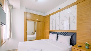 Habitación de hotel con una cama grande, armario de madera, pared con diseño de mármol y una pequeña planta en maceta.