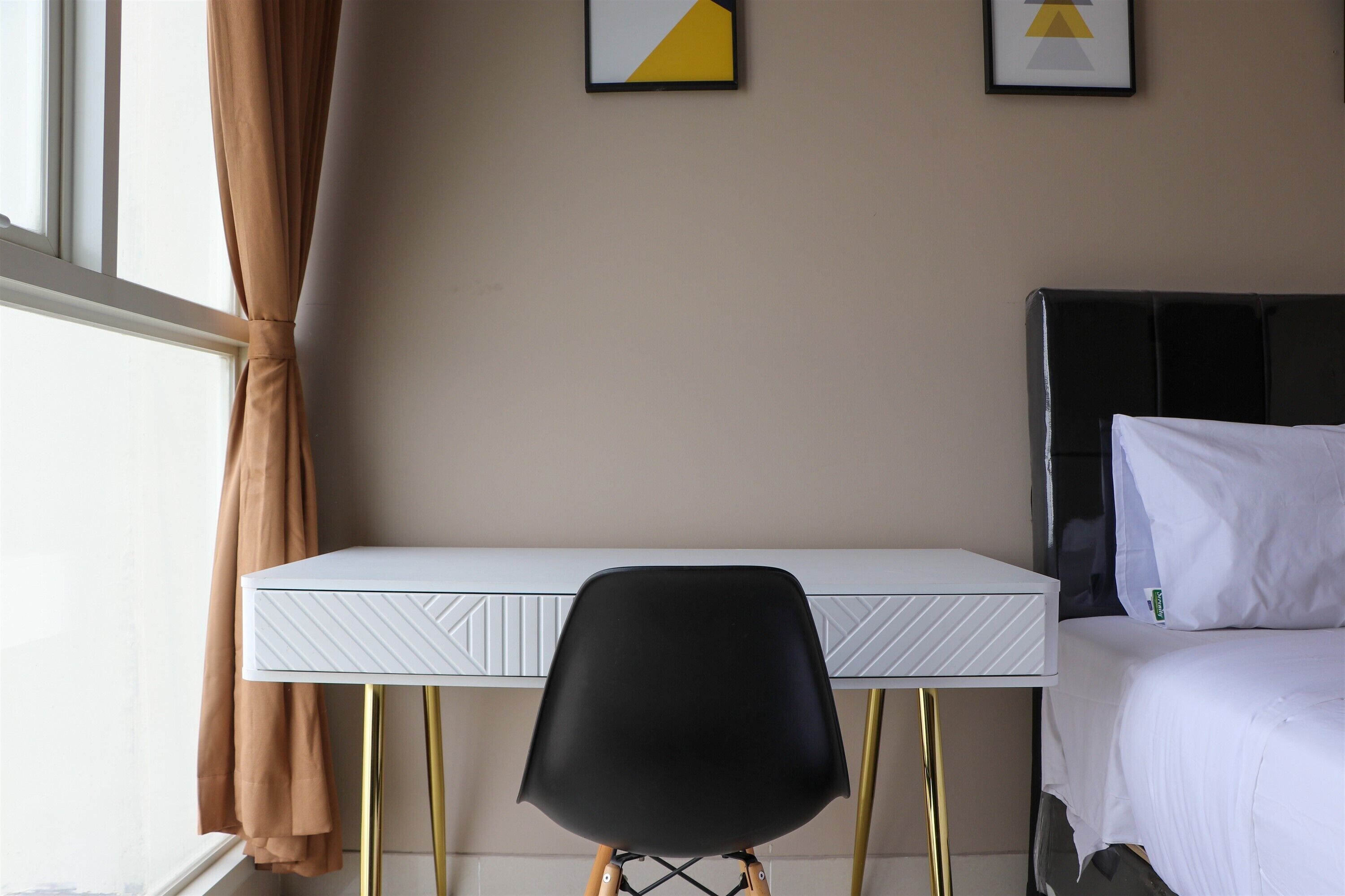 A hotel room with a bed, a desk, and a chair.