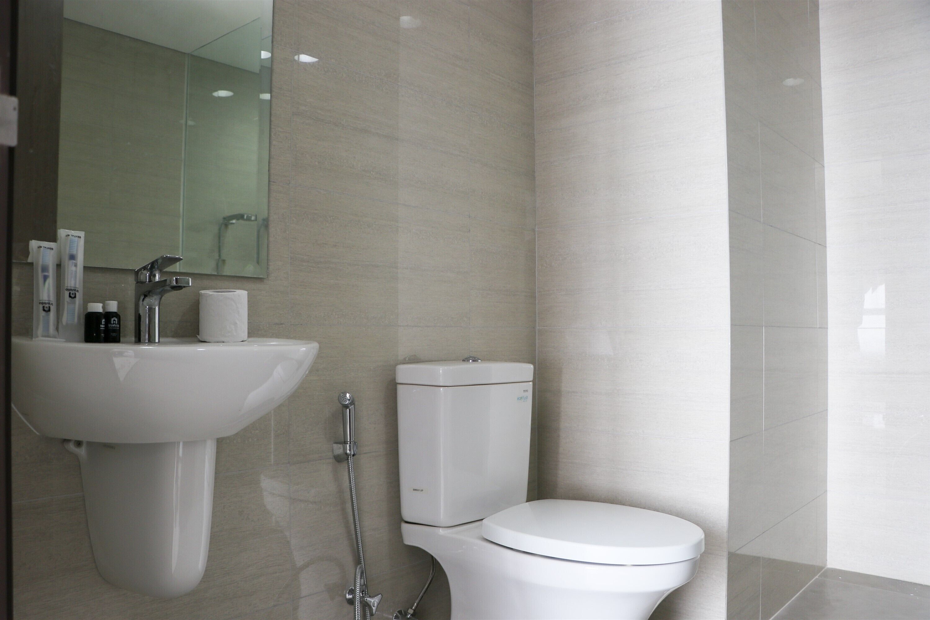 Ein modernes Badezimmer mit Waschbecken, Toilette und Dusche, alles in Weiß.