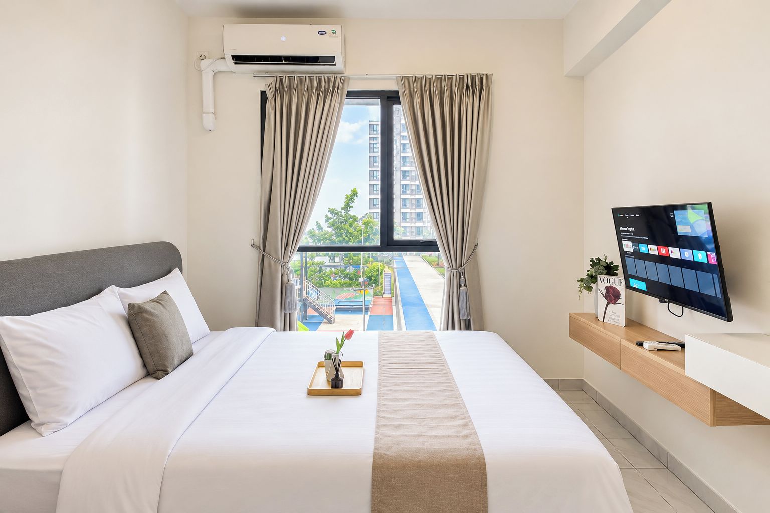A hotel room with a bed, a TV, a window with curtains, and a view of a building and greenery outside.