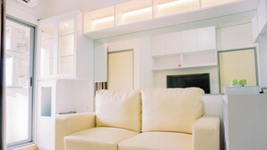 Una sala moderna con un sofá color crema, una chimenea y estanterías empotradas.
