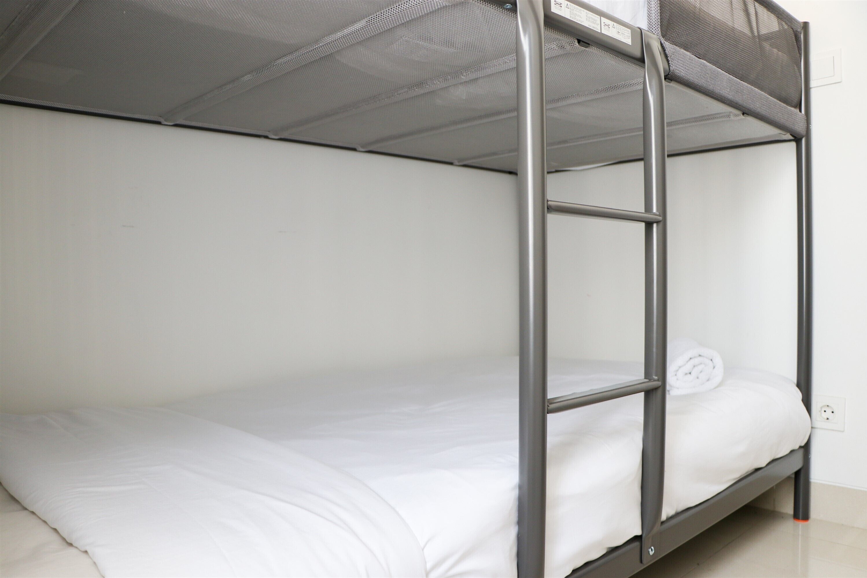 Un lit superposé avec une structure en métal et un sommier en treillis.
