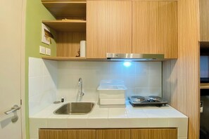 Enjoy cooking in this kitchen with an oven, compact stovetop, and stainless steel sink.