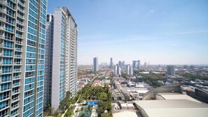 A high-rise building with a modern design, featuring a large number of windows and balconies. - Cozy Studio Connected To Mall At The Vertu Apartment (Surabaya)