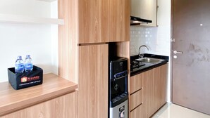 Een moderne keuken met houten kastjes, een inbouwoven en een waterdispenser.