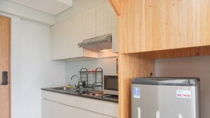 Una cocina con armarios blancos, un refrigerador de acero inoxidable y un horno empotrado.