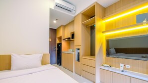 Een hotelkamer met een bed, een inbouwgarderobe, een spiegel en een klein nachtkastje.