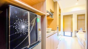 Een moderne keuken met een zwarte koelkast, houten kastjes en een aanrecht.