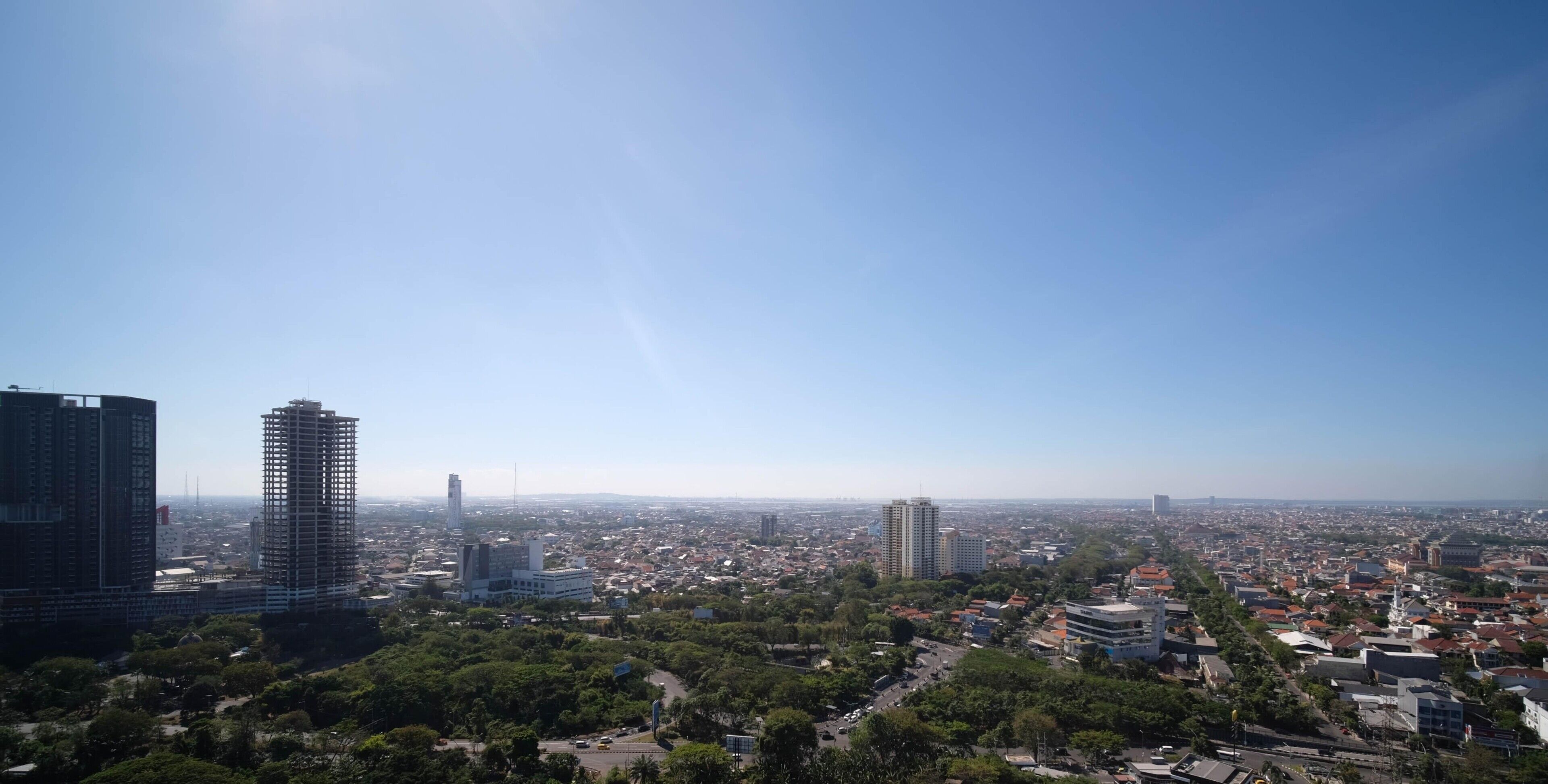 A cityscape with high-rise buildings, a clear sky, and a mix of residential and commercial structures.