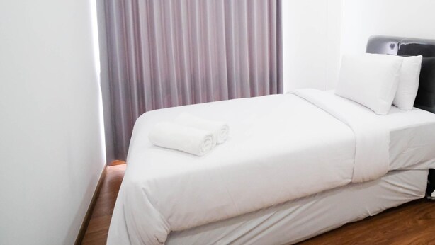 A hotel room with a bed, a window with curtains, and a headboard. - Exclusive And Spacey 3Br At Grand Sungkono Lagoon Apartment (Surabaya)