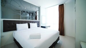 Ein modernes Hotelzimmer mit einem großen Bett, einem dekorativen Kopfteil und Blick ins Freie.
