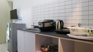 A kitchen with a refrigerator, a coffee maker, and a sink. - Simply Look And Comfy Studio Sayana Bekasi Apartment (Tarumajaya)