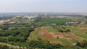 An aerial view of a rural landscape with fields, a river, and scattered buildings. - Simply Look And Comfy Studio Sayana Bekasi Apartment (Tarumajaya)
