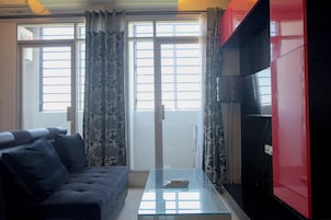 A living room with a sofa, a glass coffee table, and a red cabinet.