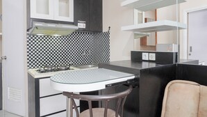 A compact kitchen with a gas stove, a dishwasher, and a checkered backsplash. - Cozy Stay 1Br At Green Pramuka City Apartment (Jakarta)