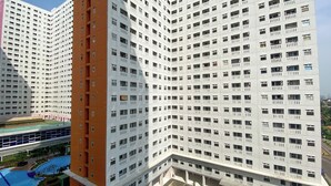 Korkea kerrostalo, jossa on useita kerroksia, parvekkeita ja uima-allasalue.