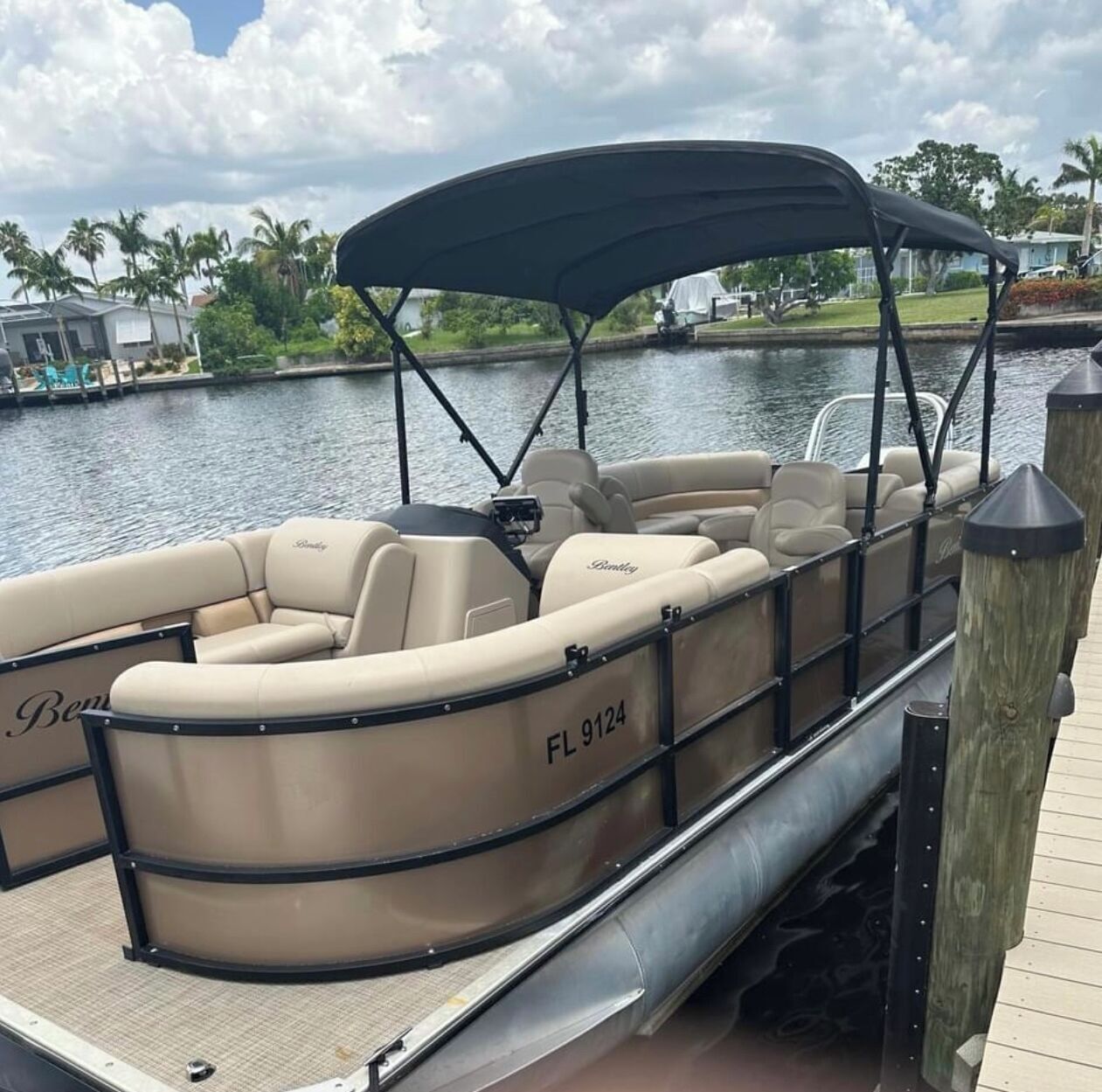 A boat with a covered seating area, a name "Bentley" on the side, and the registration number "FL 9124".