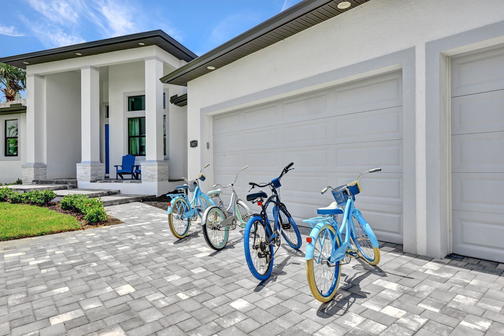 A modern house with a garage and three bicycles parked in front.