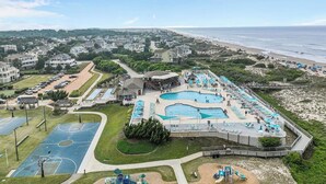 Resort com várias piscinas, uma praia e quadra de basquete.