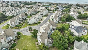 Um bairro residencial com casas, ruas e vista para o mar.