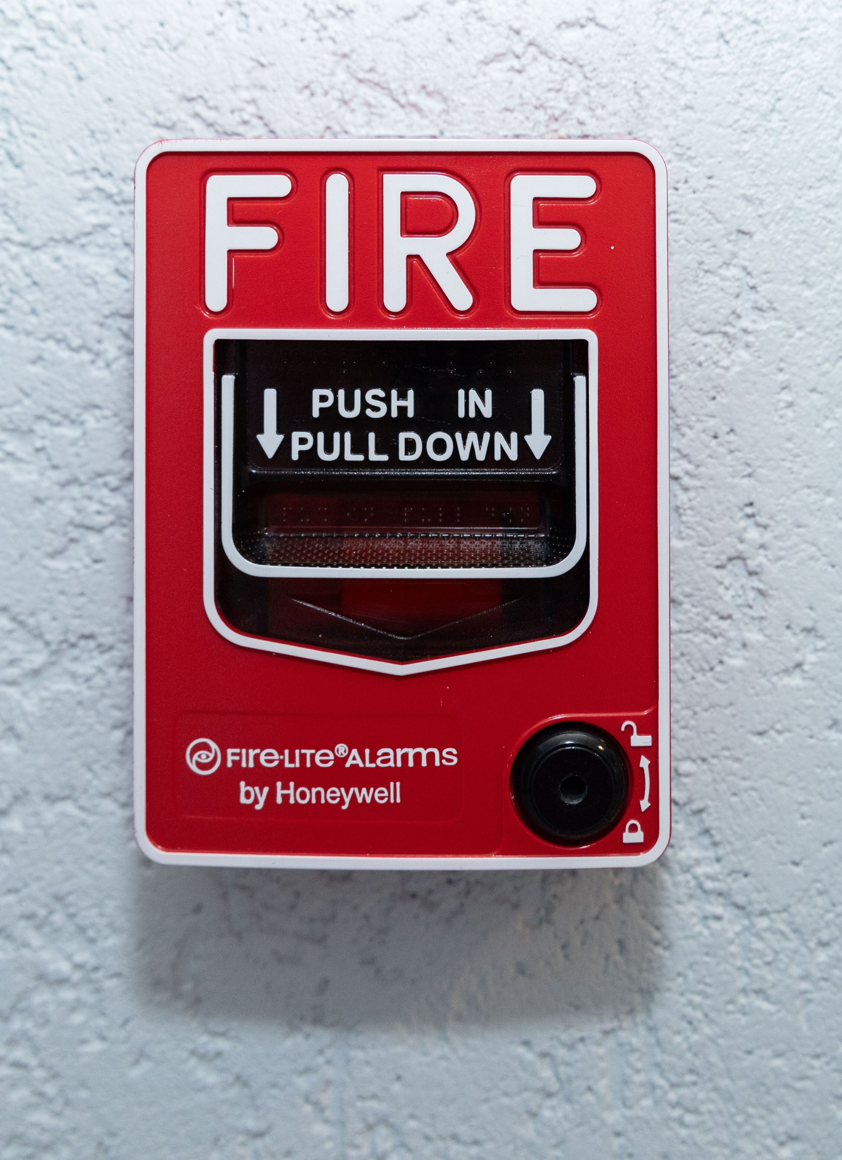 A red fire alarm with instructions to push in and pull down.