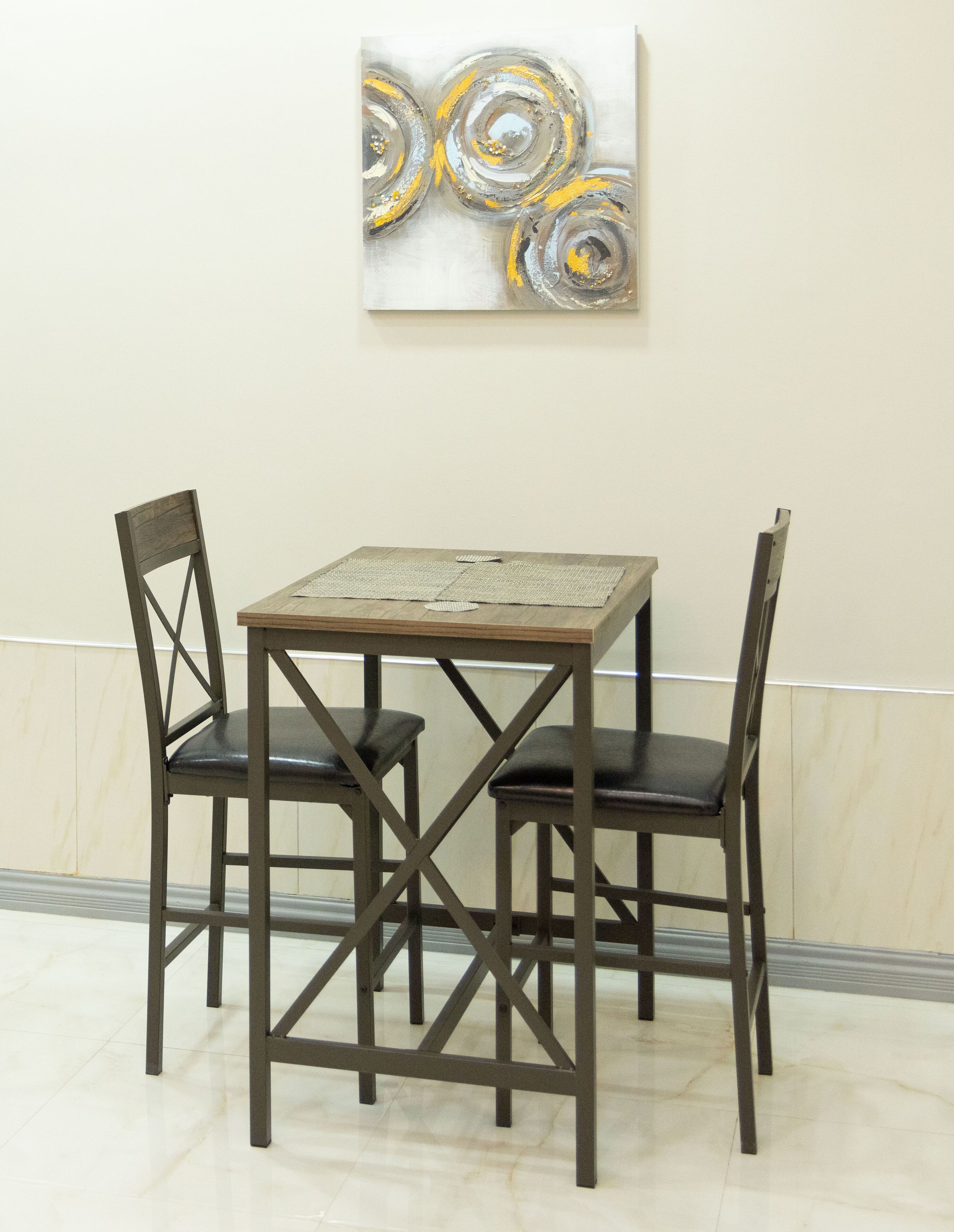 Een eettafel met vier stoelen, een abstract schilderij aan de muur en een marmeren vloer.