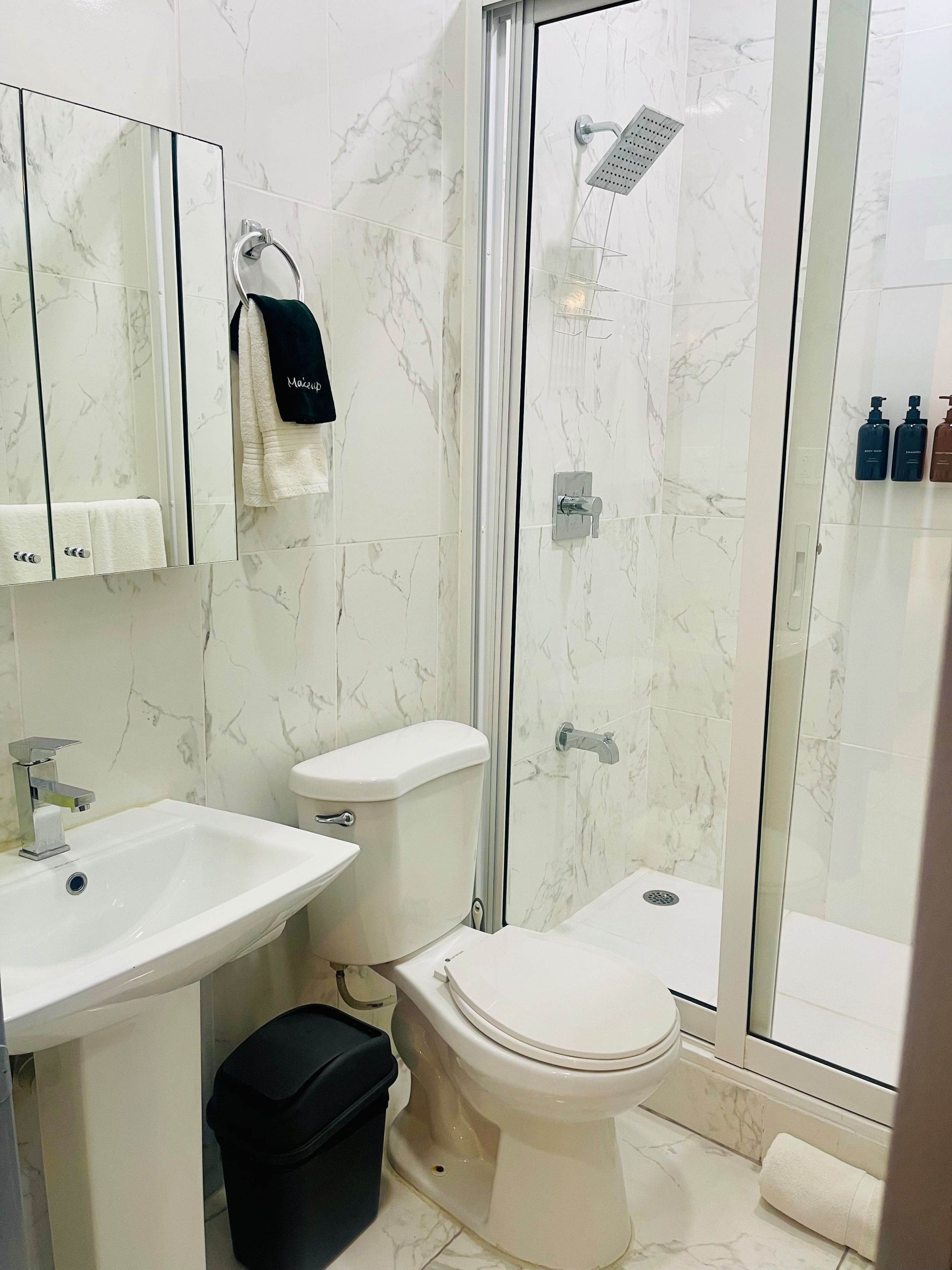 A bathroom with a toilet, sink, and shower.