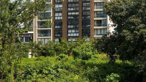 Ein mehrgeschossiges Wohngebäude mit modernem architektonischen Design, das einen zentralen Kern und einheitliche Fensteranordnungen aufweist.