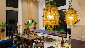 A modern dining area with a ping pong table, wooden chairs, and a blue sofa. - Carmen de Apicalá (Carmen de Apicala)