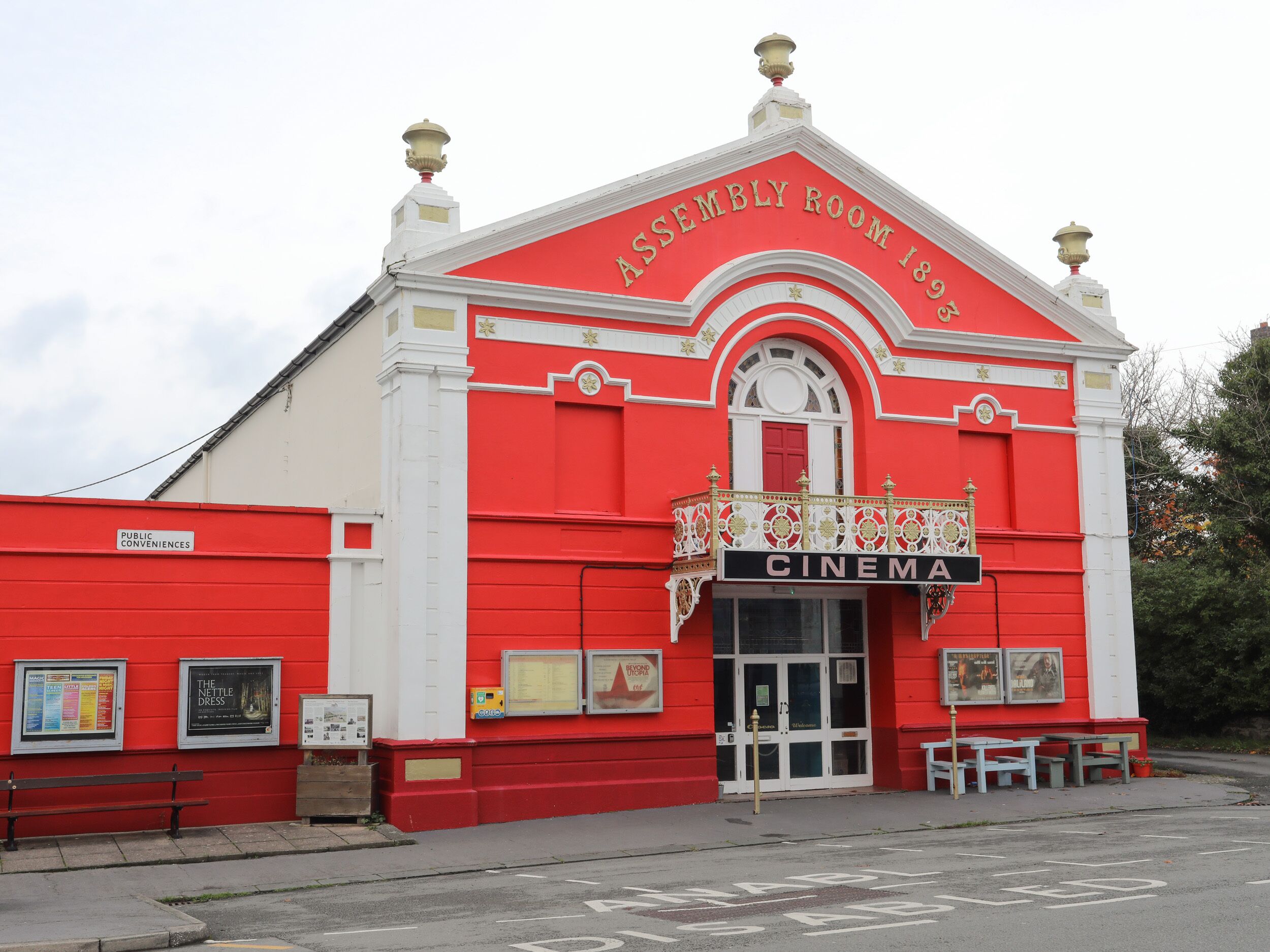 Um edifício de cinema vermelho e branco com varanda e uma placa que diz 