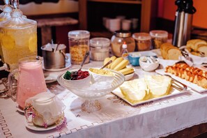 A breakfast buffet with various food items, including fruits, pastries, and beverages. - VELINN Pousada Face Norte (Ilhabela)