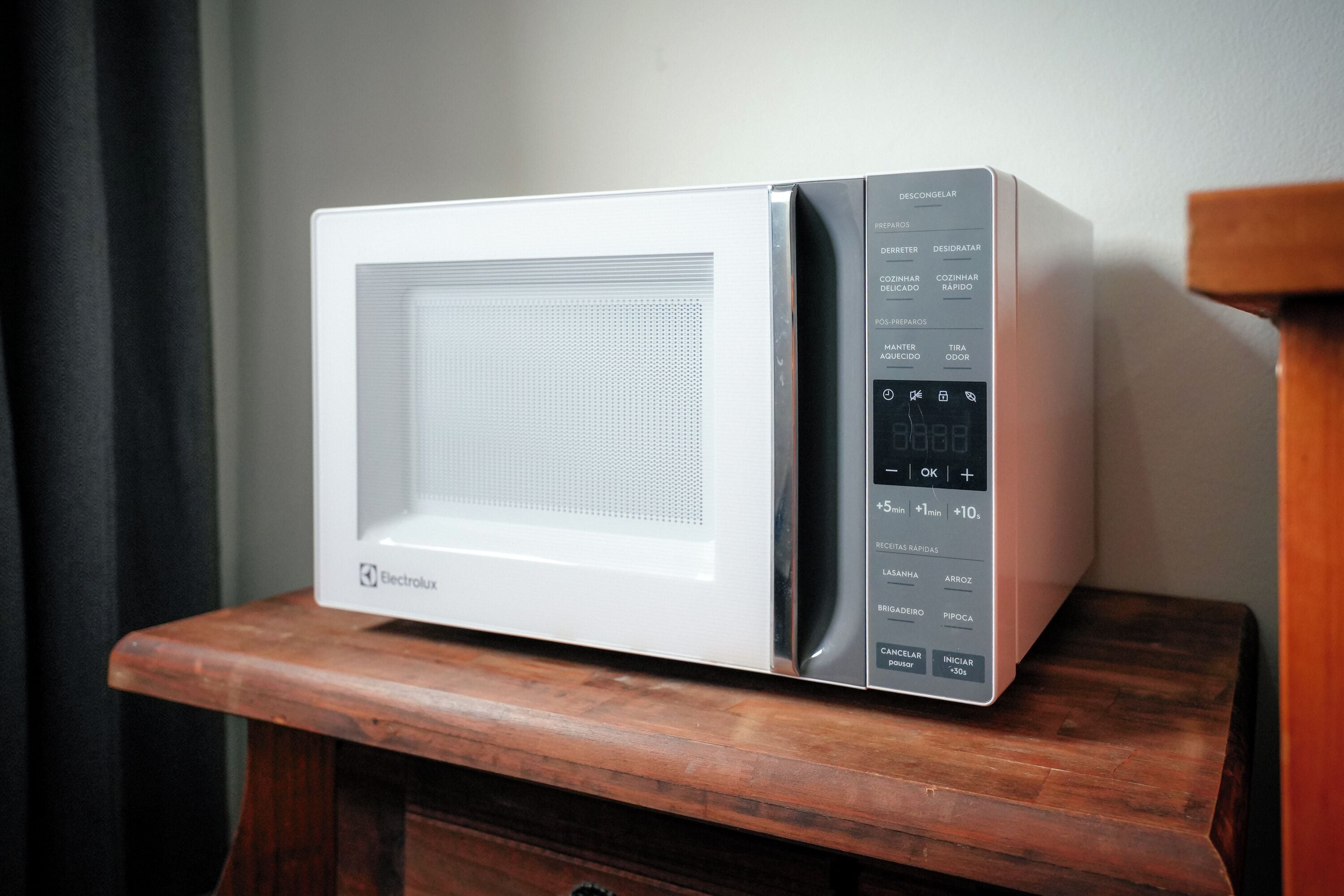 A white Electrolux microwave on a wooden table.