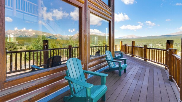 A wooden deck with Adirondack chairs and a large window offering a mountain view. - Alma Mountain Getaway w/ Private Hot Tub & Views (Alma)