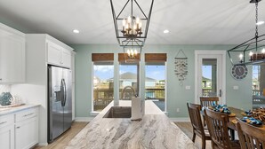 A modern kitchen with a large island, stainless steel appliances, and a view to the outside. - 5Bed / 5 Baths  Walk 2 Beach!  Arcade!  Ocean View!  Ping Pong! Fire Pit! (Crystal Beach, Texas)
